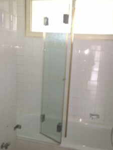 Wannenbad mit Duschabtren.