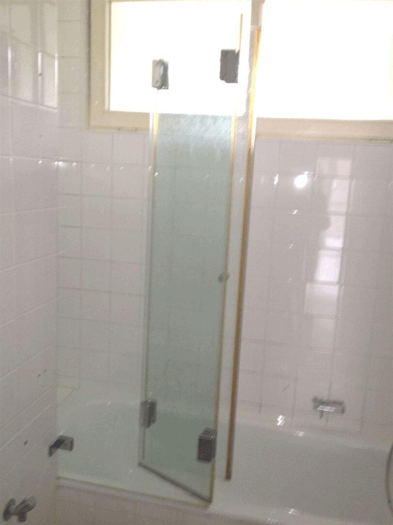 Wannenbad mit Duschabtren.