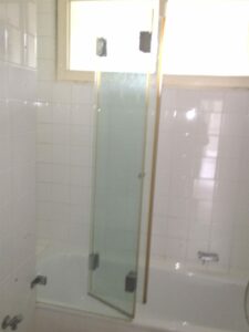 Wannenbad mit Duschabtren.